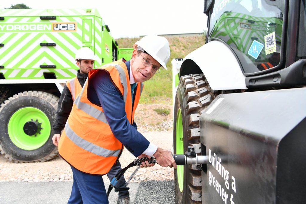 West Midlands Mayor Andy Street refuels a JCB backhoe loader with hydrogen from the new JCB refueller during a visit to JCB